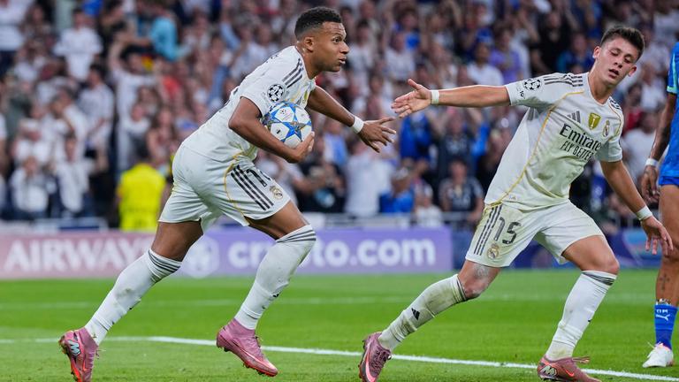 Kylian Mbappe (links) läuft nach seinem Tor mit dem Ball in der Hand über den Rasen. Mannschaftskamerad Arda Guler streckt die Hand nach ihm aus.