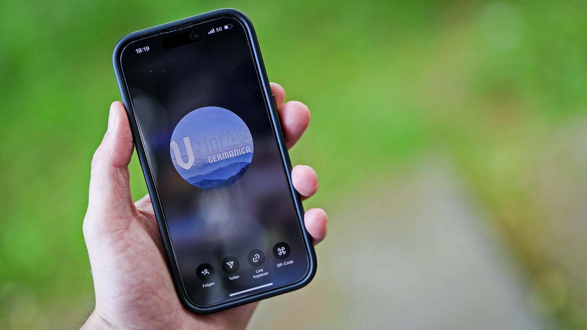 Illustration: Handydisplay mit dem Logo der rechtsextremen Jugendgruppe Unitas Germanica (Illustration).
