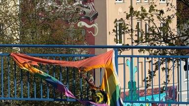 Zerrissene LGBTQ-Flagge, die an einer Reling hängt