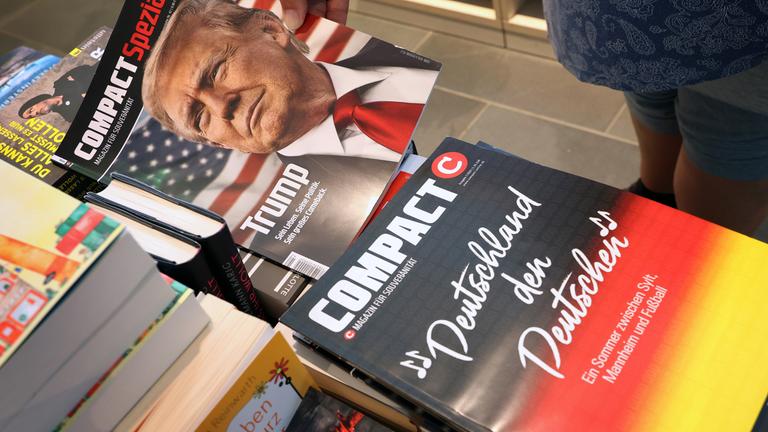 Bayern, Kempten: Eine Mitarbeiterin einer Bahnhofsbuchhandlung hält eine Ausgabe des Magazins "Compact", um es danach aus dem Sortiment zu nehmen.