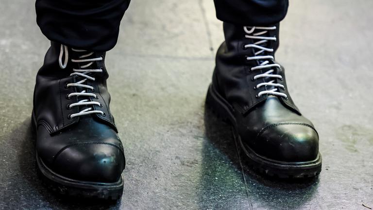 18.01.2025, Nordrhein-Westfalen, Aachen: Ein Teilnehmer einer rechtsextremen Kundgebung trägt schwarze Springerstiefel mit weißen Schnürriemen, einem weit verbreitetem Symbol der rechten Szene.
