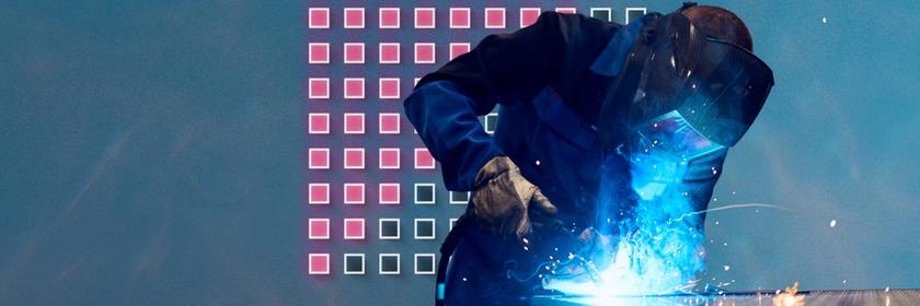 Schweißer bei der Arbeit, im Hintergrund eine Grafik