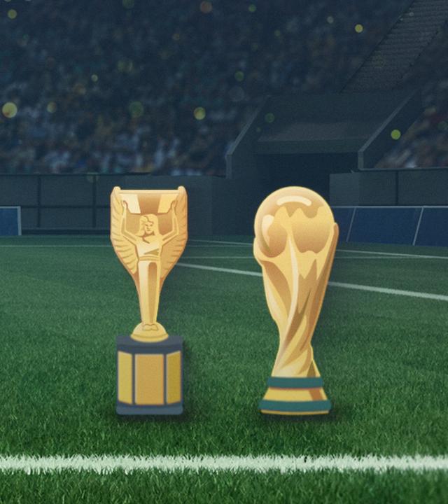 Modelle der Fußball-WM-Pokale bis 1970 bzw. seit 1974 stehen nebeneinander auf einer Rasenfläche im Stadion