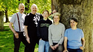 Die Familie von Oskar mit mehreren Müttern und Vätern steht vor einem Baum im Englischen Garten in München.