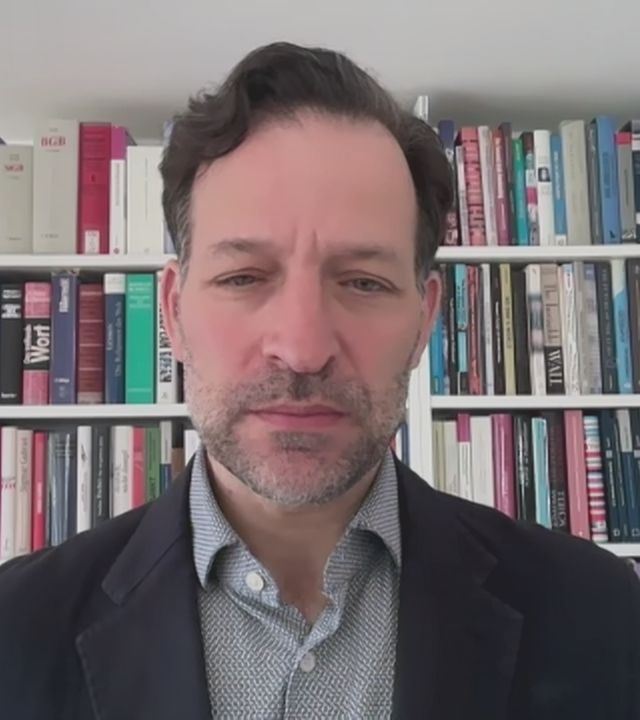 Cornelius Adebahr vor einem Bücherregal.