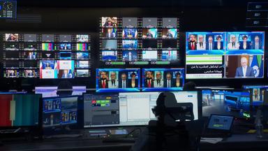 Schaltraum eines Fernsehstudios mit vielen Bildschirmen