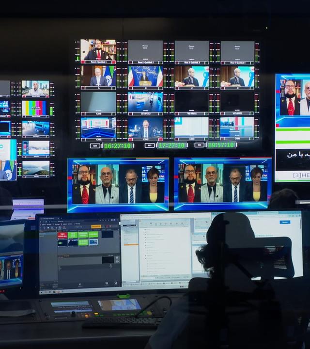 Schaltraum eines Fernsehstudios mit vielen Bildschirmen