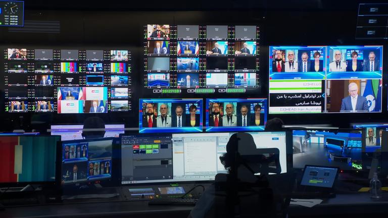 Schaltraum eines Fernsehstudios mit vielen Bildschirmen