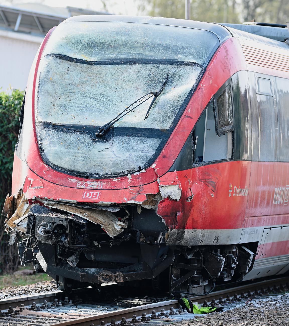 Ein Regionalzug mit beschädigter Front steht am Bahnhof auf den Gleisen. 