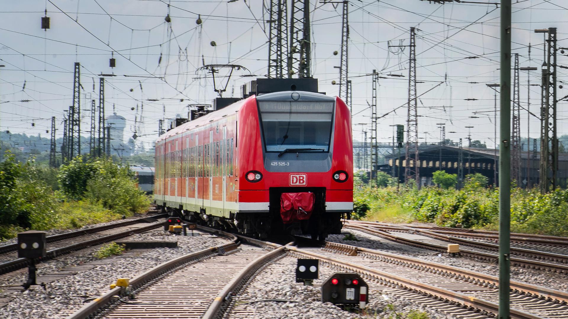 Ein Regionalzug fährt zwischen zahlreichen Oberleitungen aus dem Bahnhof Richtung Dortmund