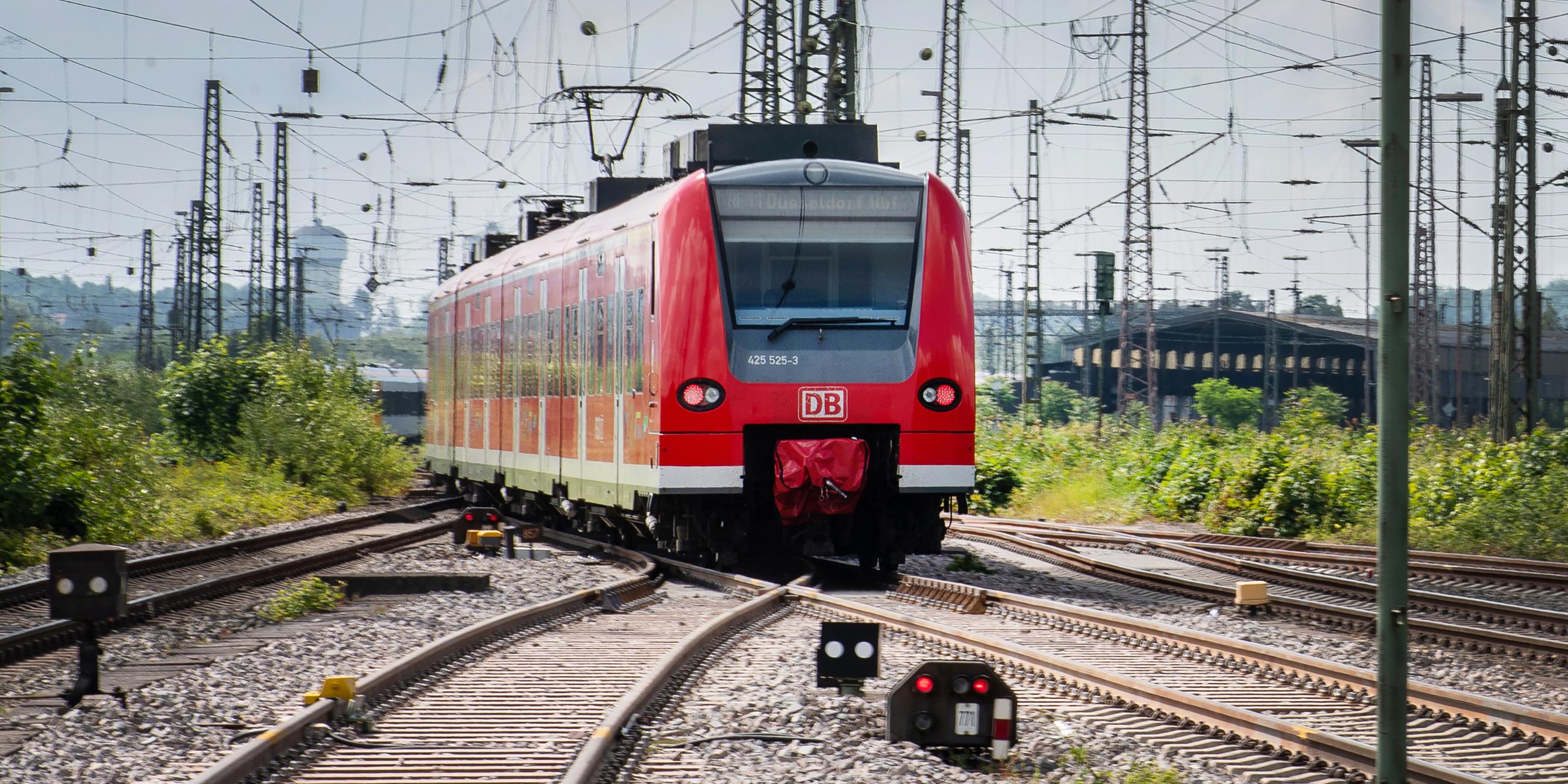 Ein Regionalzug fährt zwischen zahlreichen Oberleitungen aus dem Bahnhof Richtung Dortmund