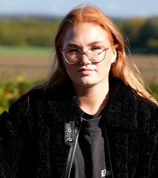 Die junge Mutter Annemarie vor einem Feld.