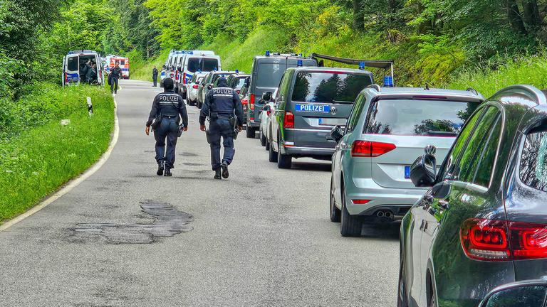 Polizisten sind bei einer Durchsuchung eines Grundstücks am Ortsrand von Althengstett in Baden-Württemberg im Einsatz.