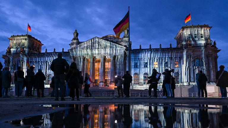 08.06.2025, Berlin: Bei der Generalprobe für die Projektion anlässlich des 30. Jahrestags der Reichstag-Verhüllung wird das Gebäude angestrahlt. 