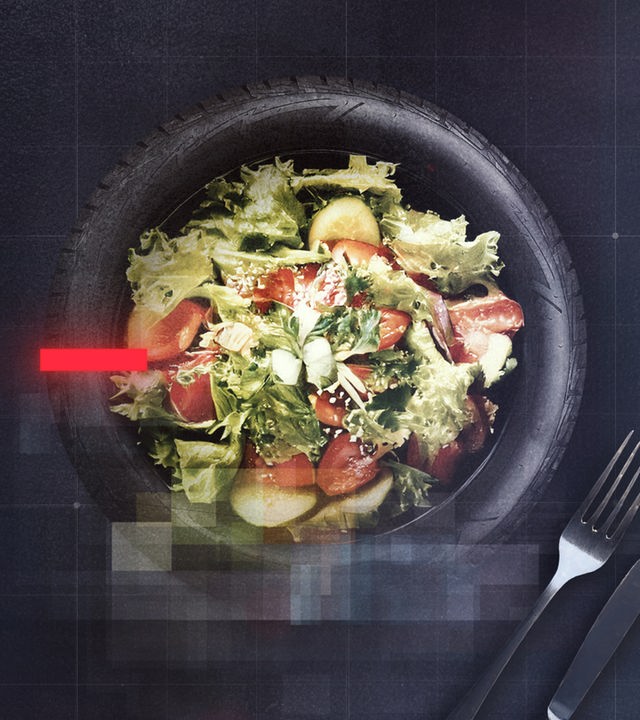 Reifen, der einen Teller darstellt und auf dem Salat liegt, rechts und links davon Messer und Gabel