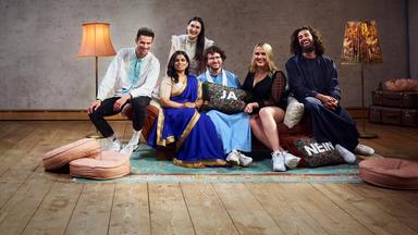 Die sechs Bewohner der Glaubens-WG sitzen auf dem Sofa im Wohnzimmer und lachen gemeinsam in die Kamera.