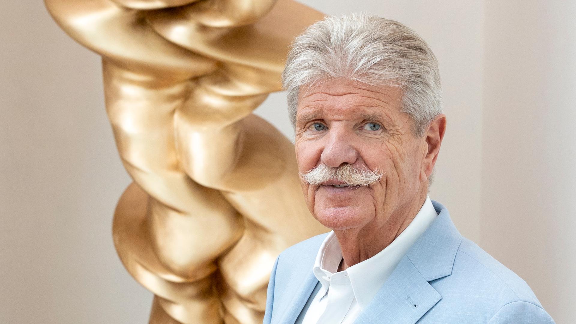 Reinhard Ernst steht vor einem Werk des Künstlers Tony Cragg
