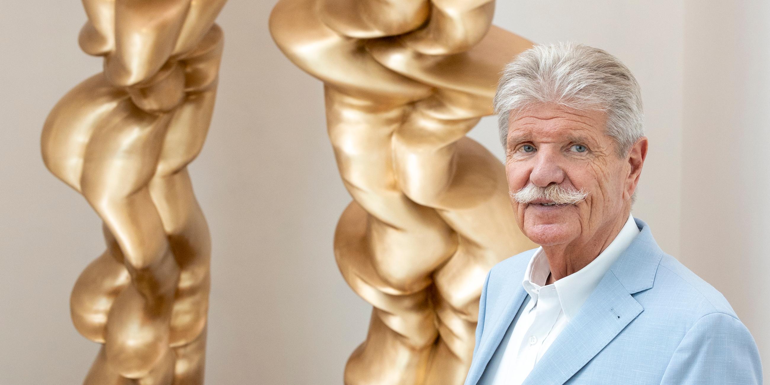 Reinhard Ernst steht vor einem Werk des Künstlers Tony Cragg