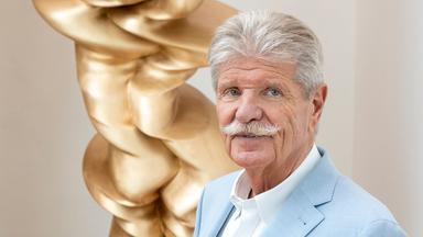 Reinhard Ernst steht vor einem Werk des Künstlers Tony Cragg