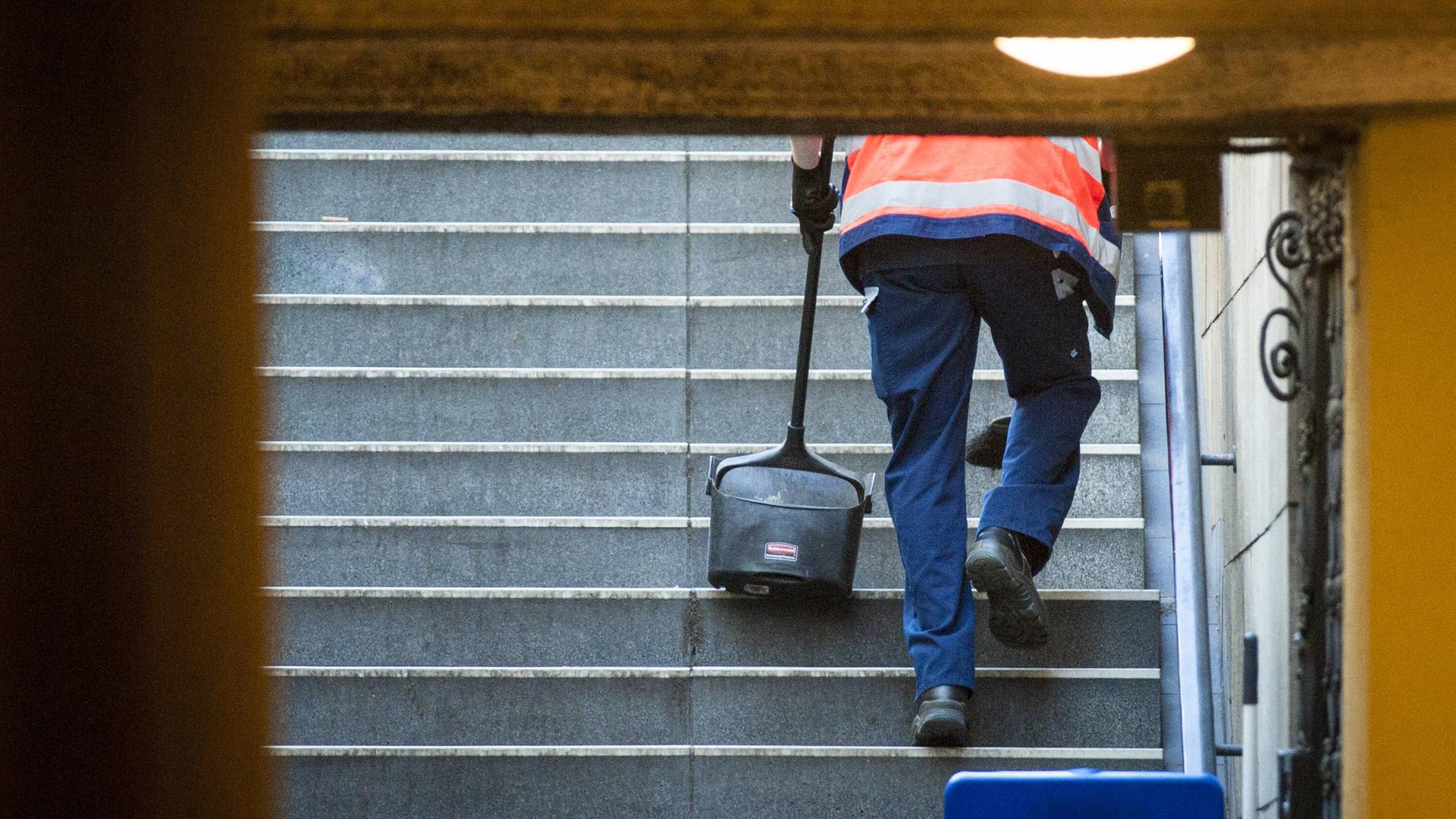 Symbolbild: Reinigungskraft säubert Treppen zu Berliner U-Bahnhof