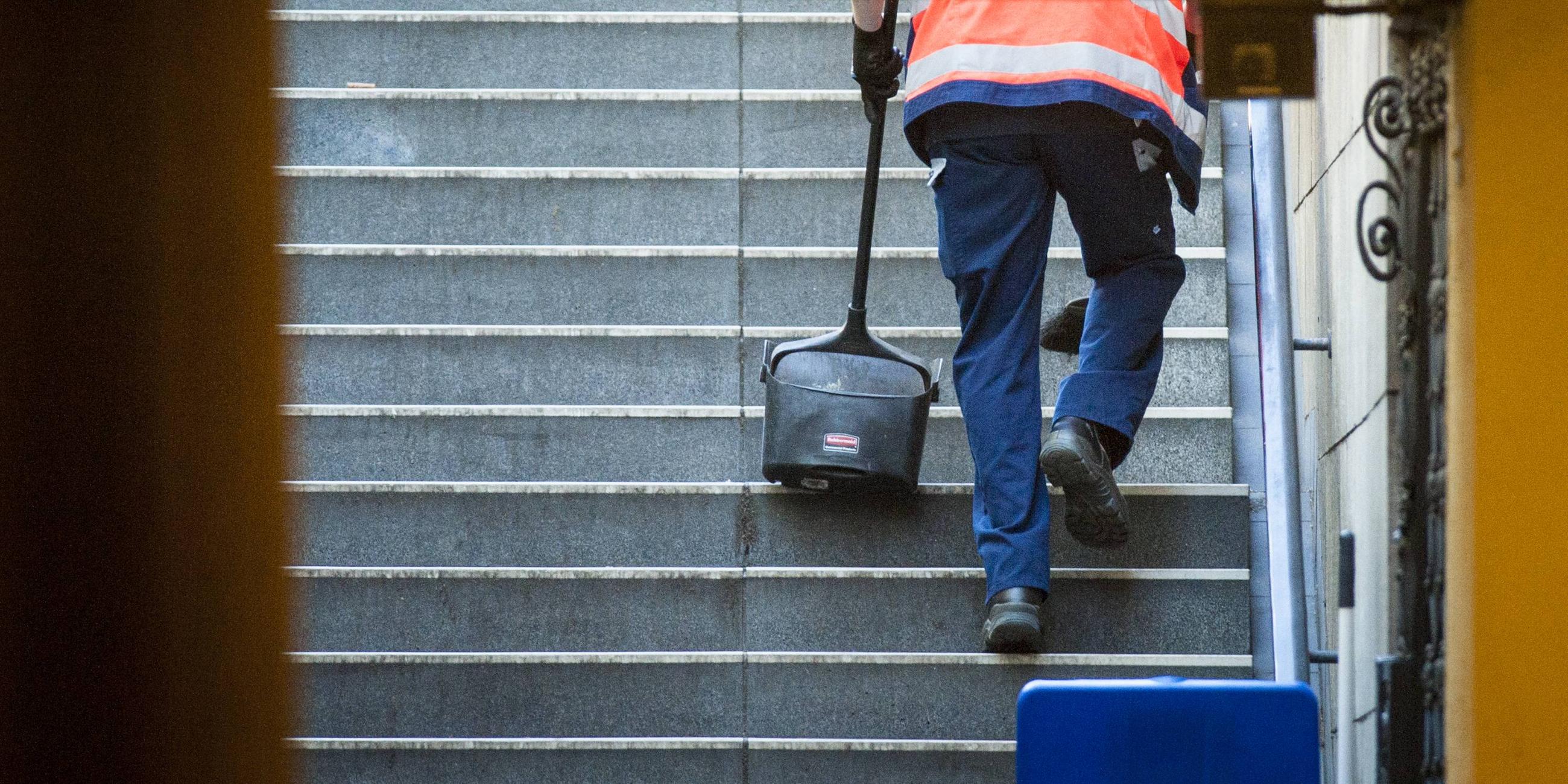 Symbolbild: Reinigungskraft säubert Treppen zu Berliner U-Bahnhof