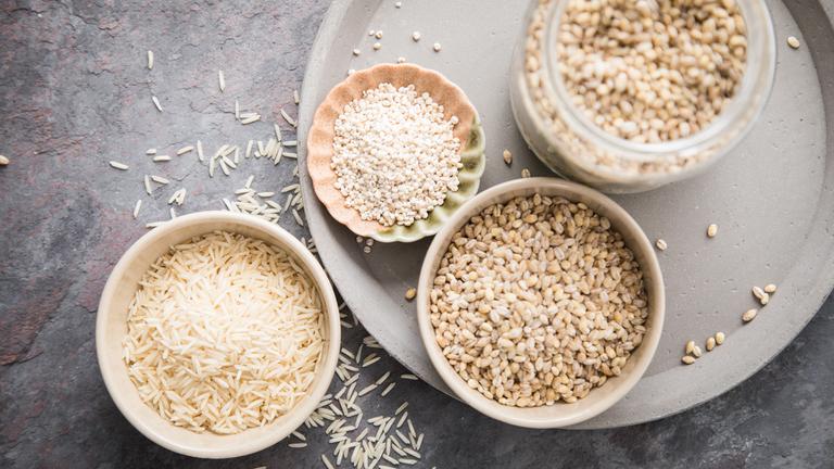 Reis und Graupen sind jeweils in Schüsseln gefüllt.