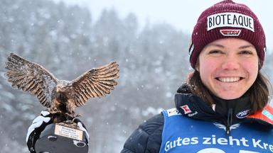 Agnes Reisch hält die Trophäe für ihren dritten Platz beim Skispringen in Villach in der rechten Hand.