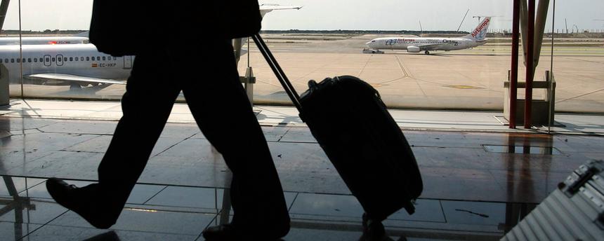 schatten eines reisenden mannes mit rollkoffer am flughafen