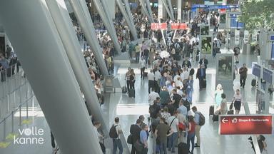 Viele Reisende am Flughafen Düsseldorf in Warteschlangen.