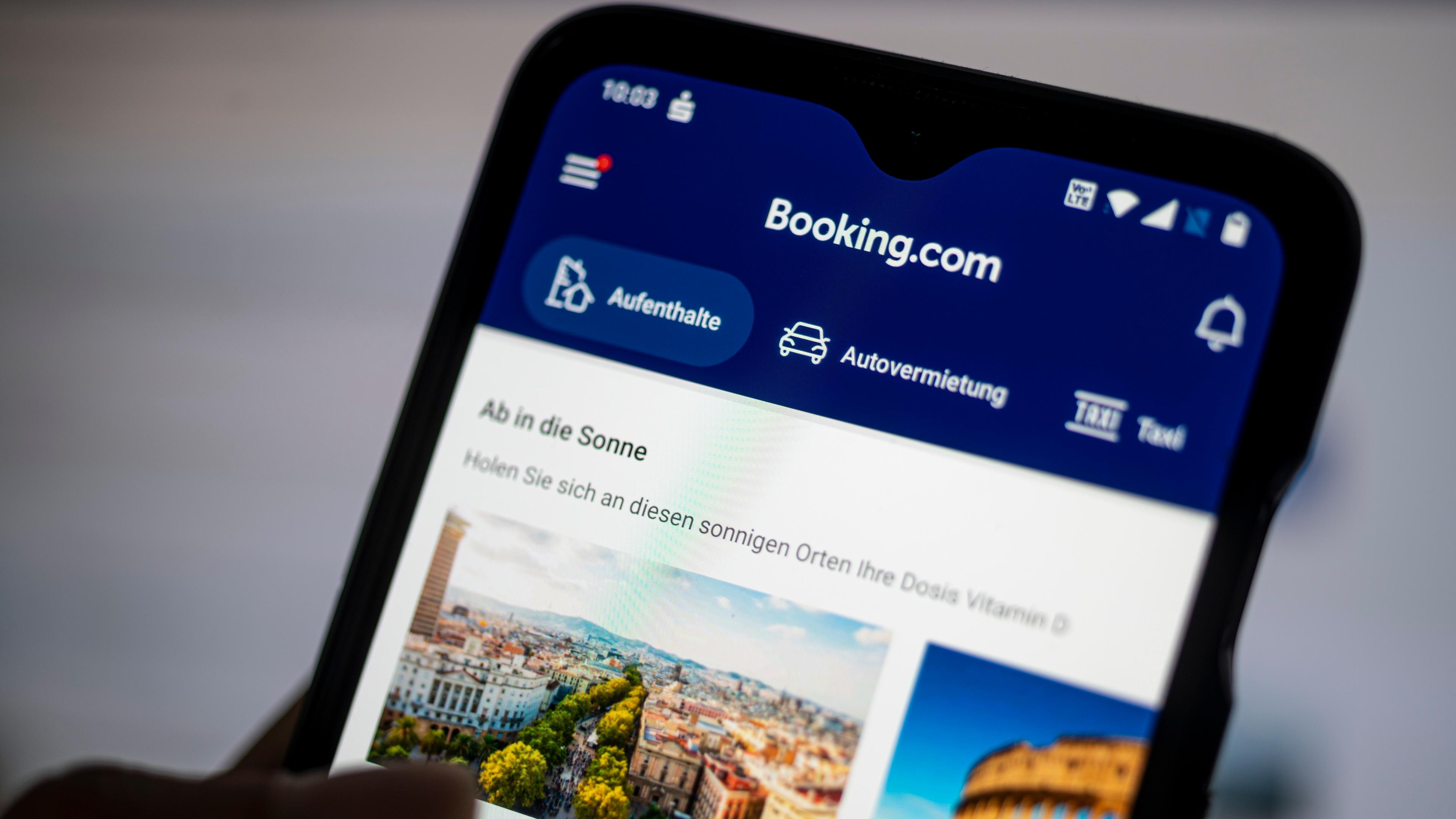 Auf einem Smartphone ist die App des Reiseportals Booking.com zu sehen.