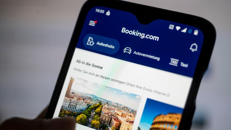 Auf einem Smartphone ist die App des Reiseportals Booking.com zu sehen.