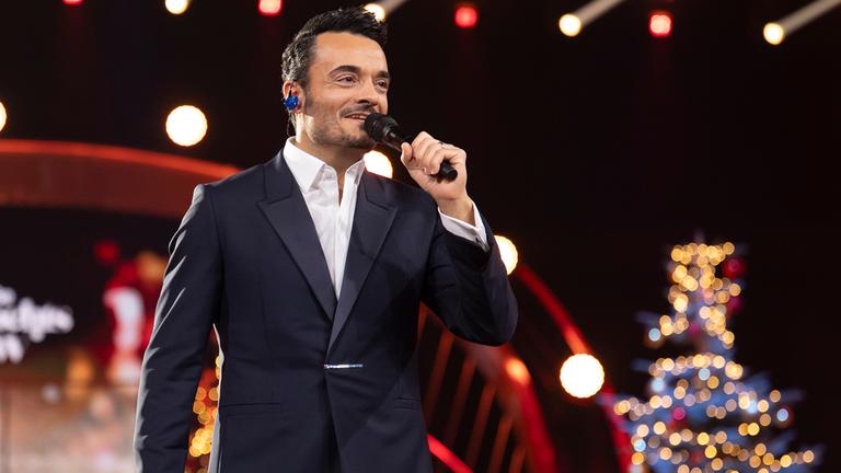 Giovanni Zarrella moderiert die ZDF-Spendengala mit einem Mikrofon in der Hand.