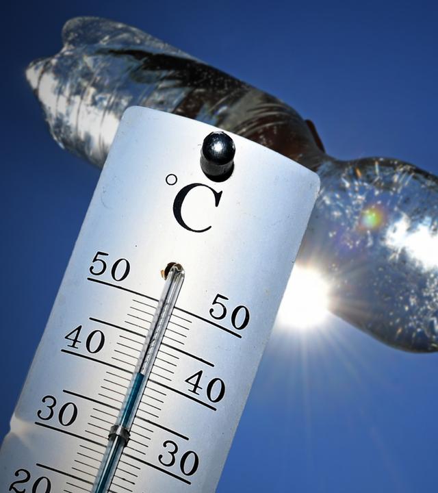 Rekordverdaechtige Temperaturen um die 40 Grad Celsius an. Junge trinkt Wasser aus einer Plastikflasche bei grosser Hitze im Sommer 2026