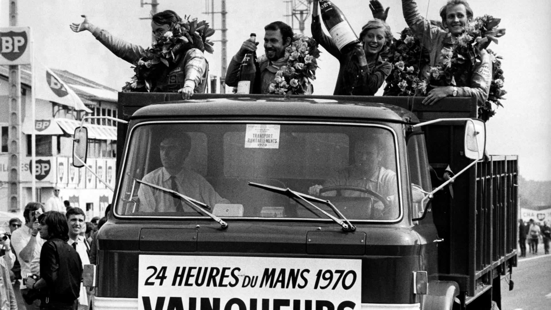 Rennfahrer Hans Herrmann (links) und Richard Attwood (rechts) feiern ihren Sieg im Rennen für Porsche von Le Mans im Jahre 1970.