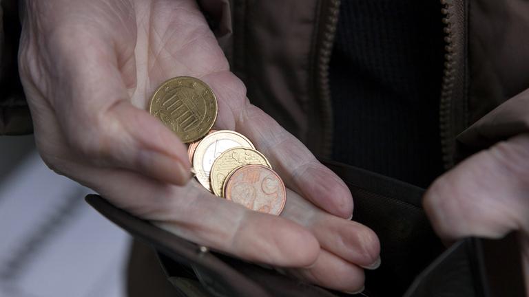 Archiv: Eine Rentnerin hält am 06.02.2016 in Berlin Kleingeld und ein Portmonnee in der Hand 