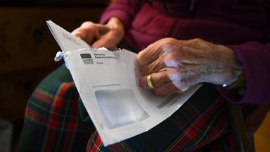 Seniorin hält ihren Rentenbescheid in der Hand