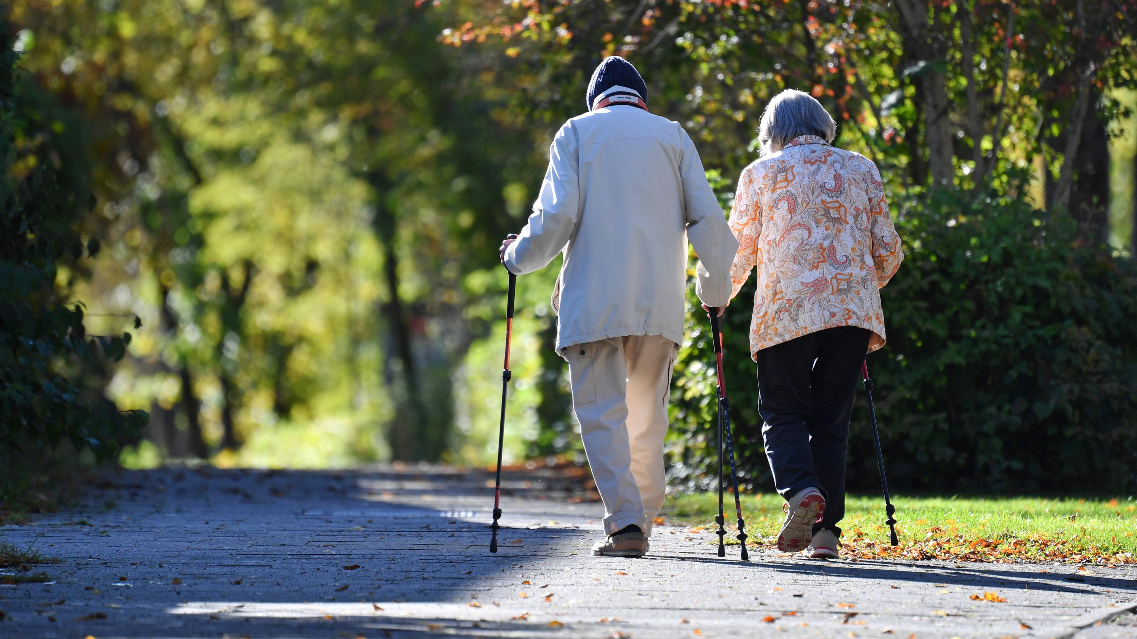 Symbolbild: Zwei alte Menschen mit Nordic Walking-Stöcken