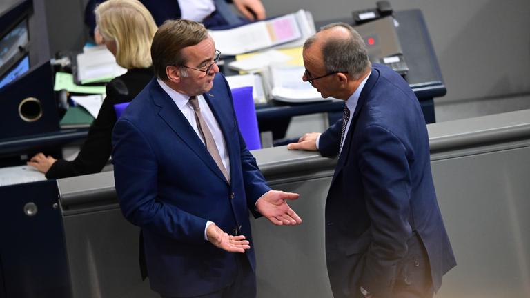 Boris Pistorius (SPD, l), Verteidigungsminister, und Bundeskanzler Friedrich Merz (CDU) sprechen am Rande der Sitzung des Bundestags. Thema ist die Rentenreform. 
