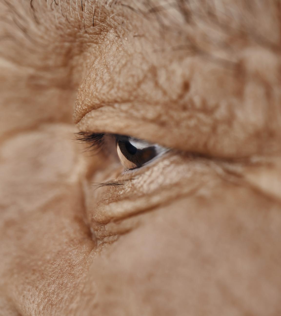 Ein alter Mann schaut geradeaus.