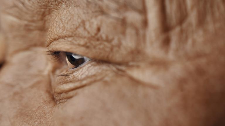 Ein alter Mann schaut geradeaus.