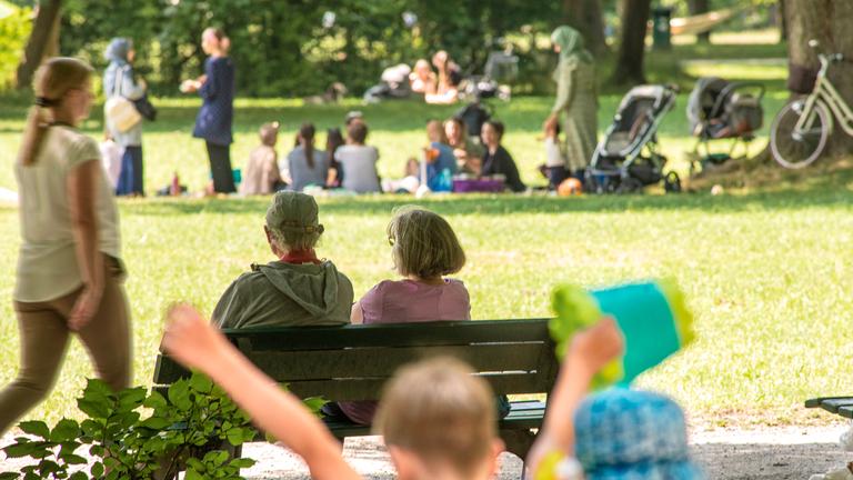 Menschn aller Generationen genießen den Sonnenschein im Park