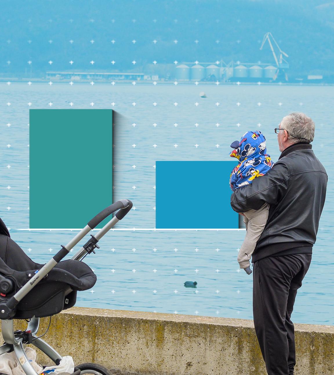 Ein Mann hält ein Baby, im Hintergrund ist Wasser zu sehen.