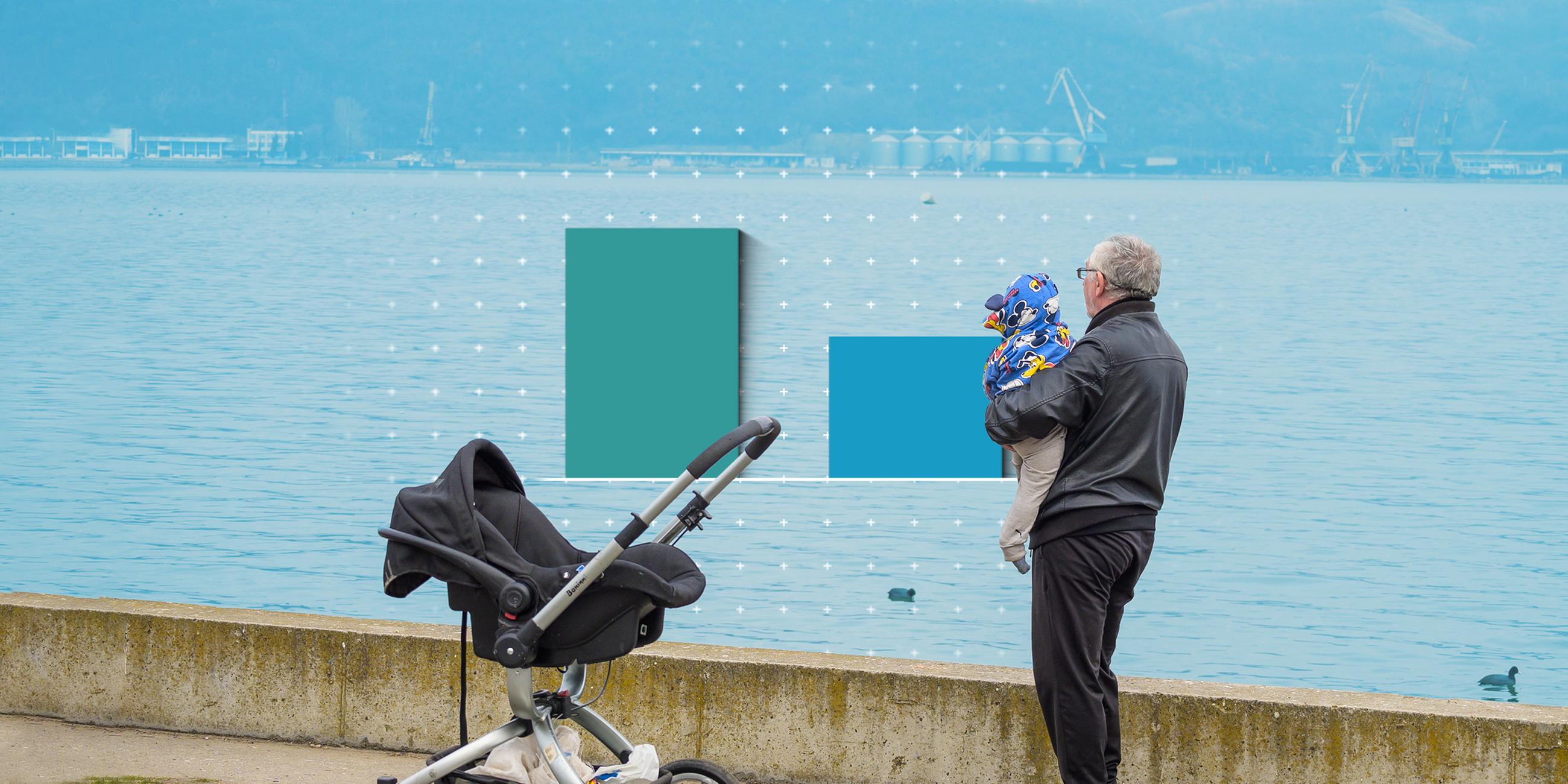 Ein Mann hält ein Baby, im Hintergrund ist Wasser zu sehen.