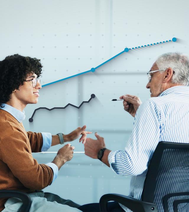 Eine jüngere und eine ältere Person sitzen vor einem Schreibtisch und reden miteinander. Dahinter ist eine Grafik mit steigenden Kursen eingefügt.