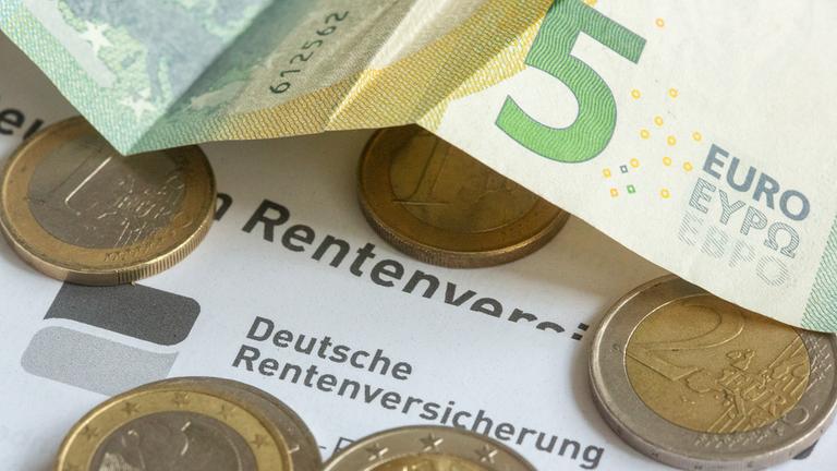 Geld liegt auf einem Rentenbescheid