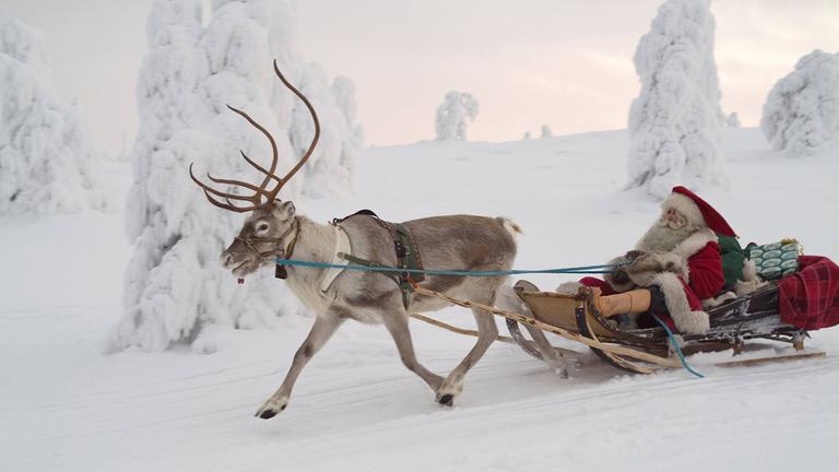 Weihnachtsmann auf einem Rentierschlitten in Lappland.