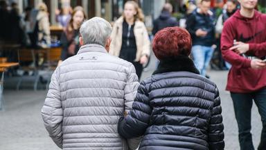 Älteres Ehepaar in der Fußgängerzone von hinten