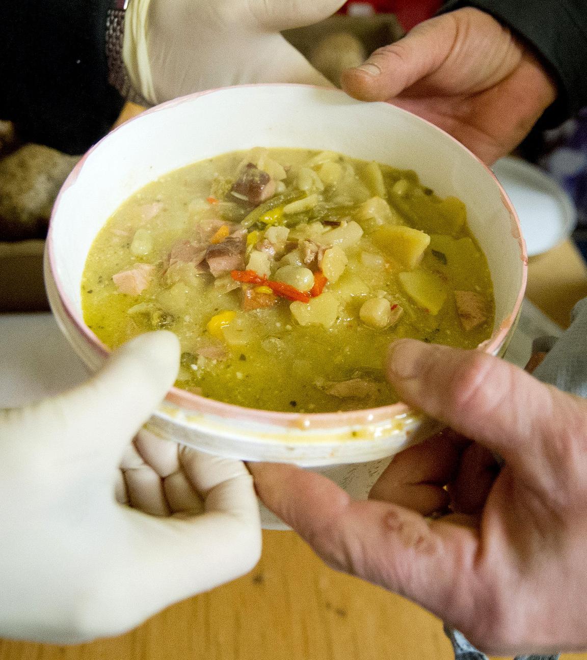 Ein alter Mann erhält eine Suppe in der Tafel in Wiesbaden.