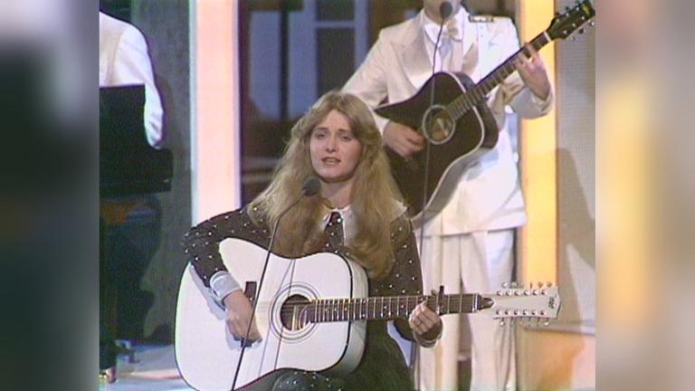 Nicole im schwarzen Kleid und ihrer weißen Gitarre.