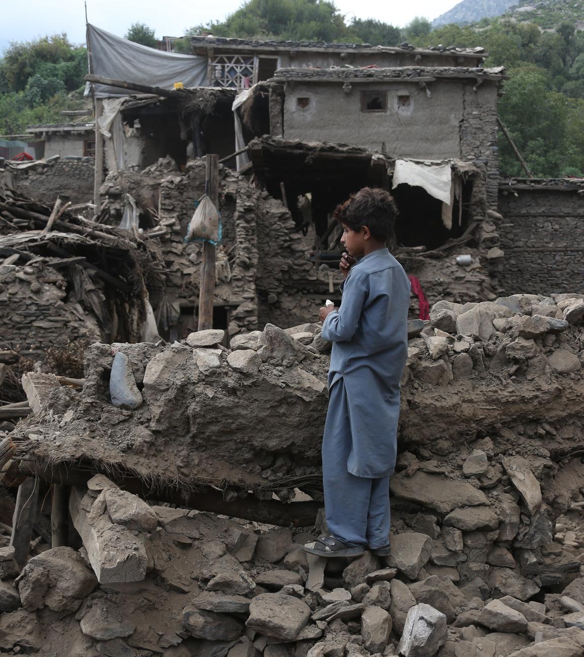 Ein Junge steht auf Trümmern im vom Erdbeben betroffenen Gebiet im Bezirk Nurgal in der Provinz Kunar in Afghanistan.